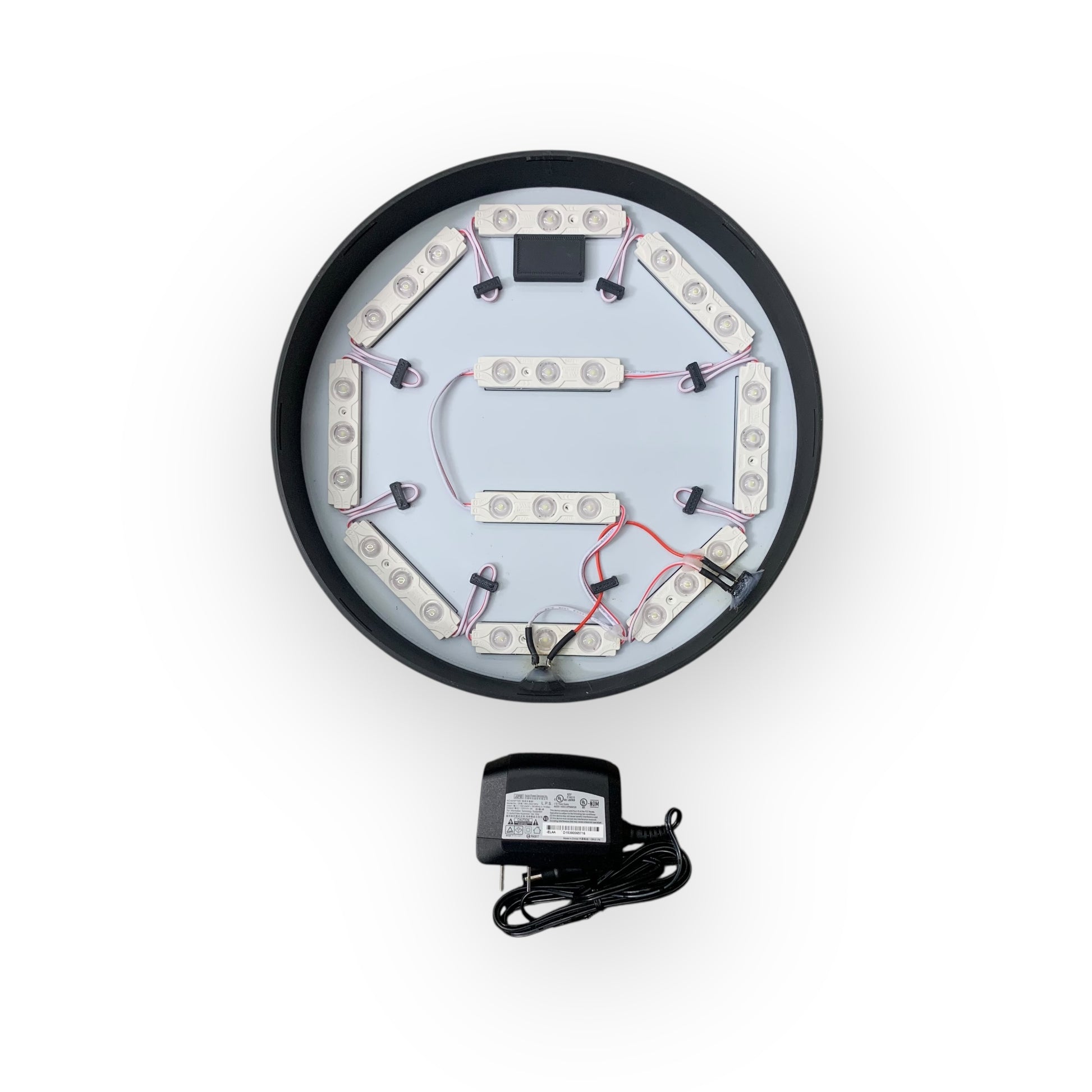 Inside of LED indoor BRP sign showing 12V led modules with a power adapter on a white background