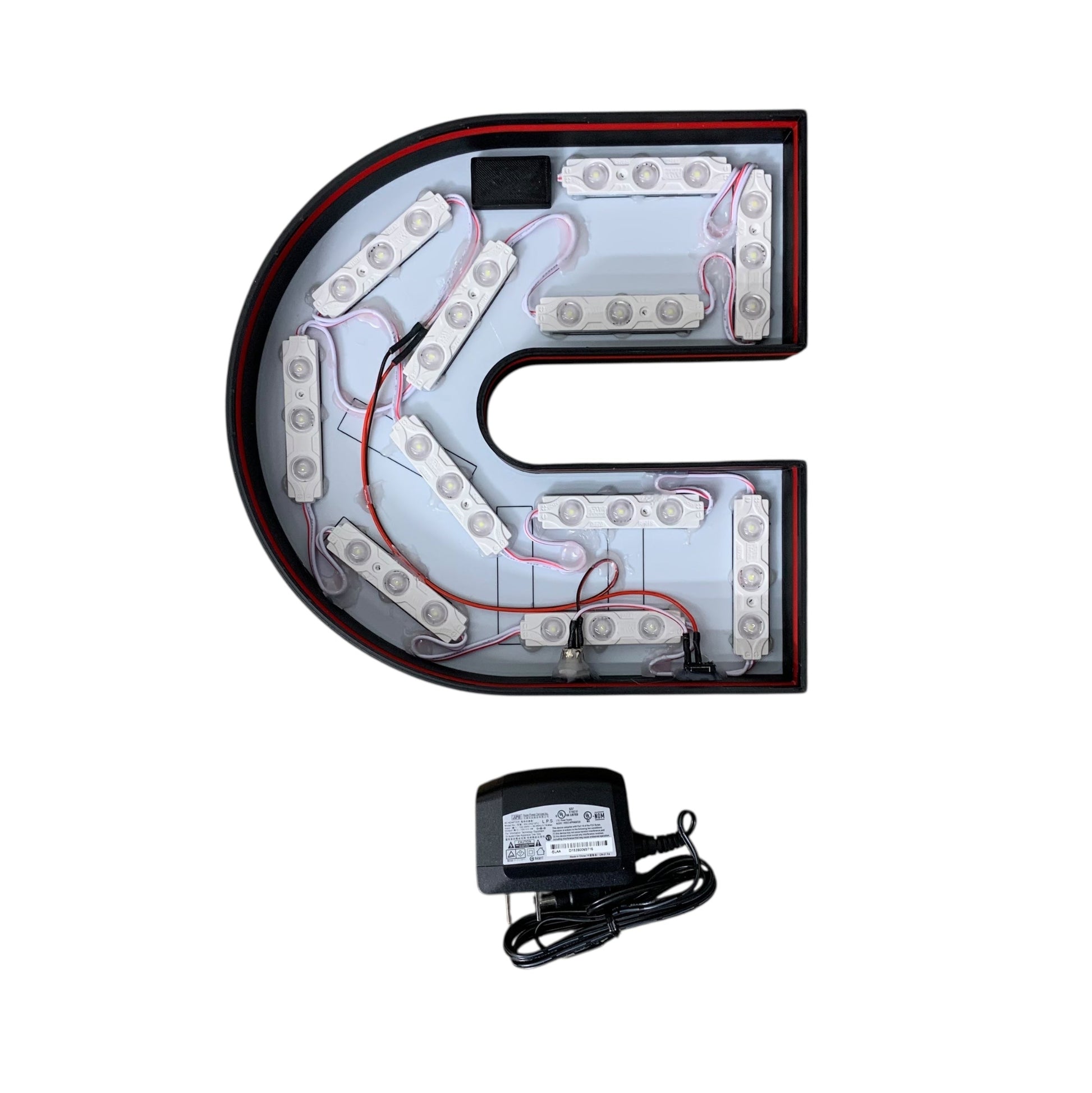 Inside of Cummins LED light with power adapter on a white background