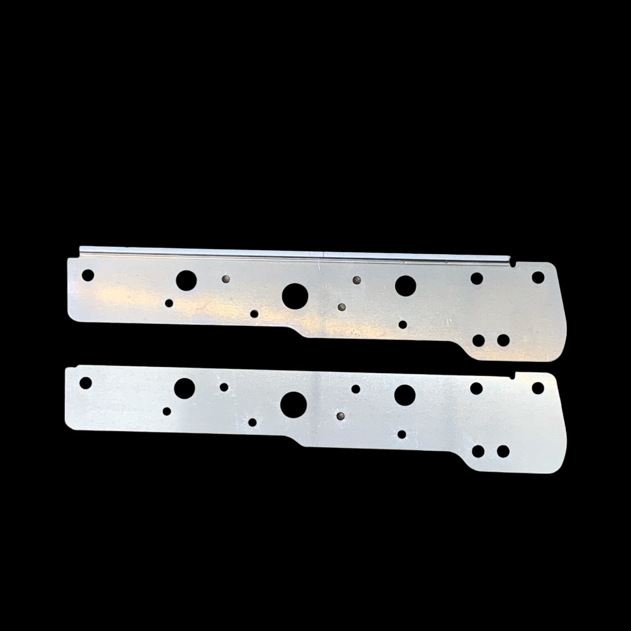 Two metallic brackets with multiple holes on a black background