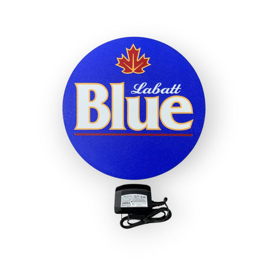 Labatt Blue logo on a blue circular led indoor sign with a power adapter below.