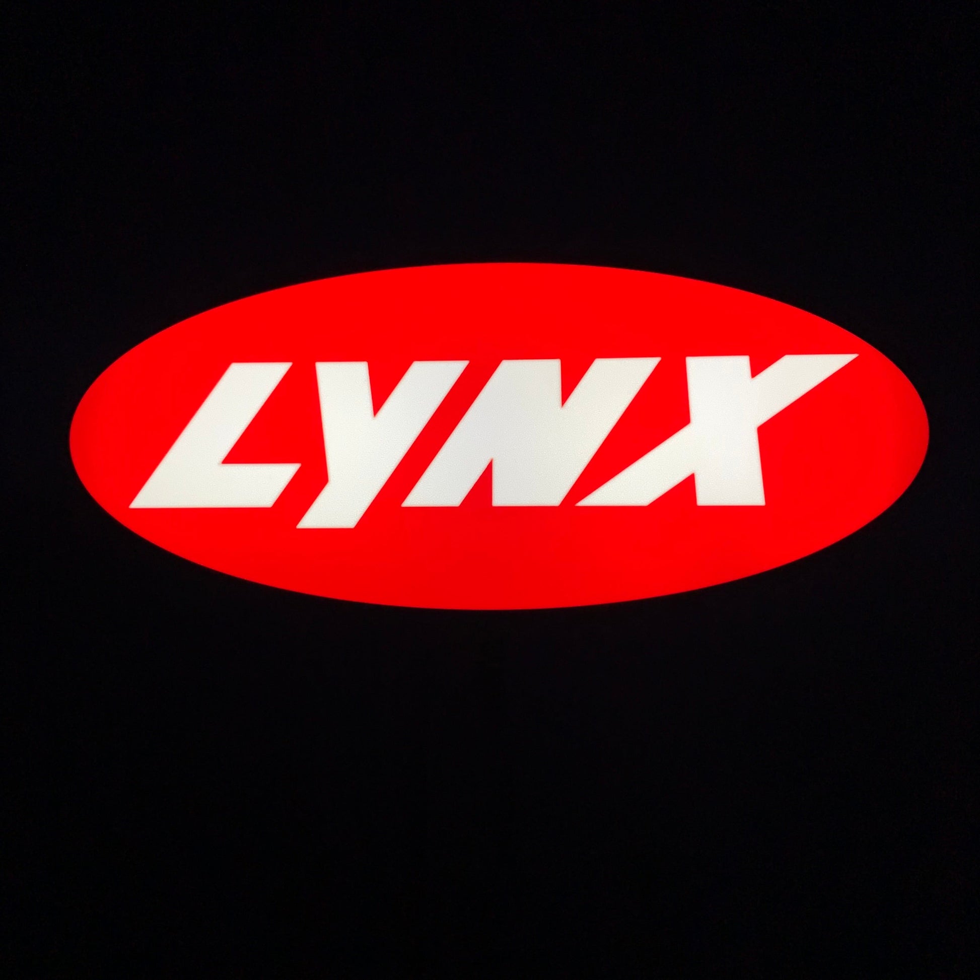 Red oval with 'LYNX' on a led sign in white on a black background