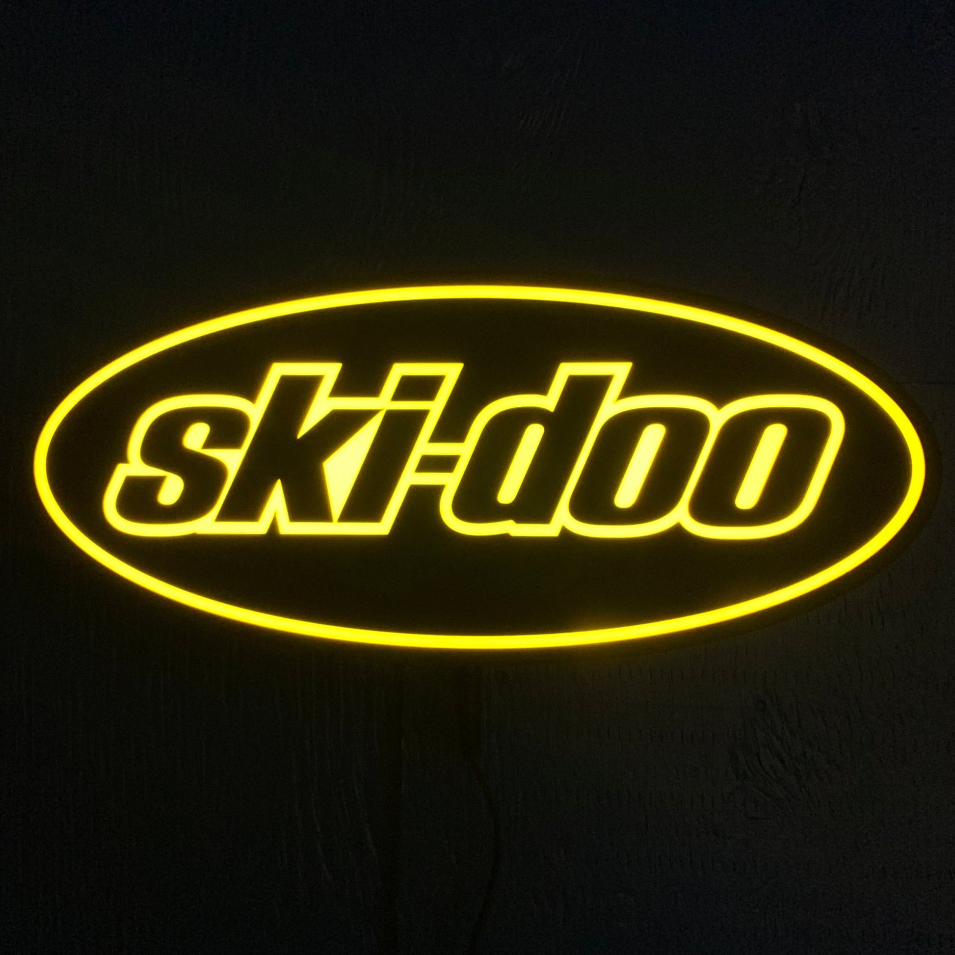 Yellow 'Ski-Doo' led sign lit up on a black background